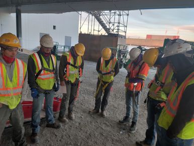 crew members praying for each other at the start of each day