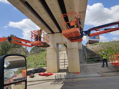 working to install the cables for the netting to attach to on this bridge in bismarck