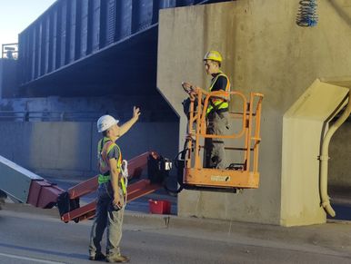 tech foreman giving instructions to install bird netting under this railroad bridge