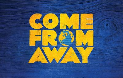 Come From Away logo with globe on a blue wooden background.