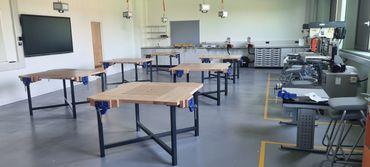 Empty workshop with wooden tables and machinery.