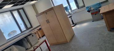 Empty workshop with wooden cabinets and tables.