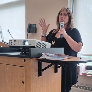 Woman speaking into a microphone during a presentation.