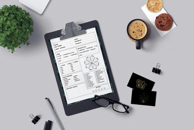 Clipboard and coffee mugs and business cards on desk.