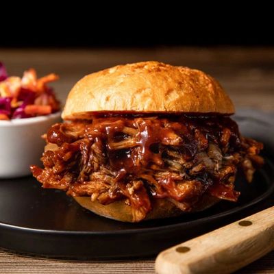 Barbecue pulled pork sandwich with sauce on a bun.