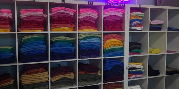 Organized shelves with neatly folded colorful clothes.