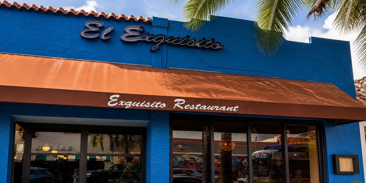 Exterior of El Exquisito Restaurant with blue walls and a brown awning.