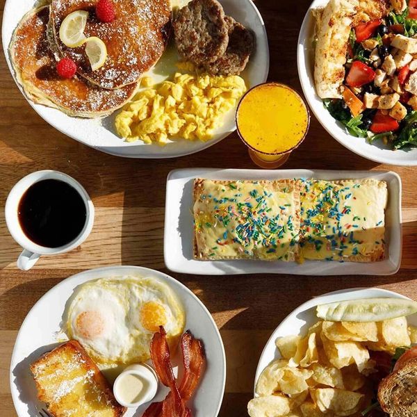 Assorted breakfast and lunch dishes on a wooden table.