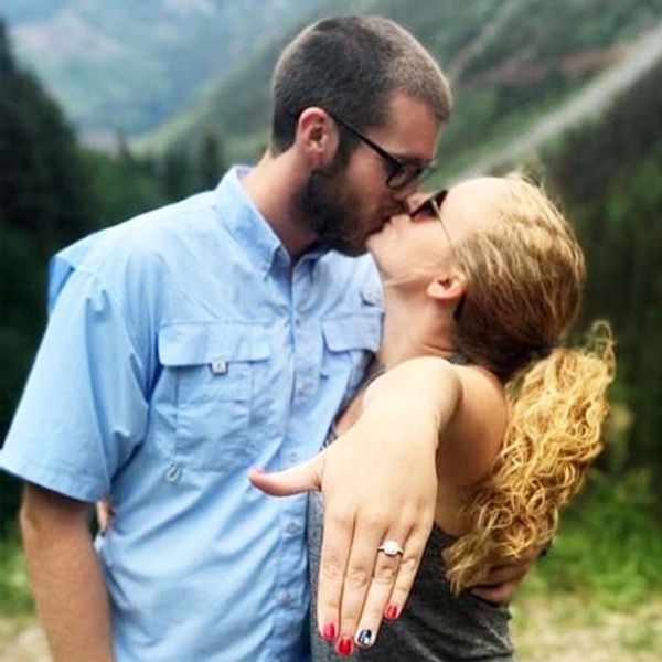 happy couple recently engaged on a mountain top