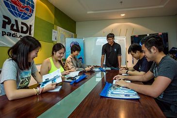 Group studying at table with PADI banner.