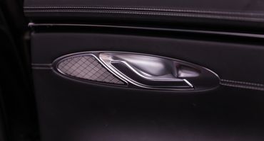 Close-up of a sleek car door handle with stitching detail.