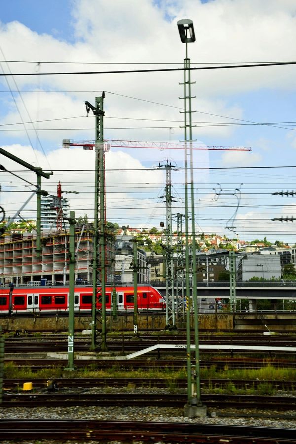 Red train through green poles in Germany
