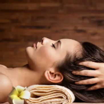 Woman relaxing with eyes closed during spa treatment.