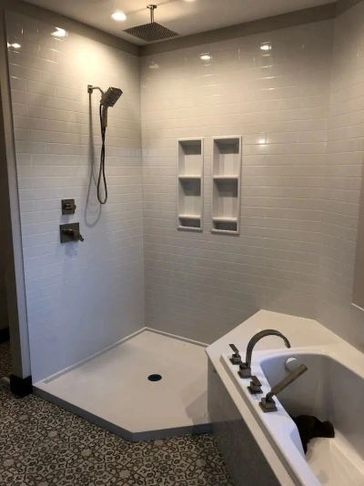 White Onyx subway-tile shower with dual recessed niches, rainfall showerhead and handheld shower.