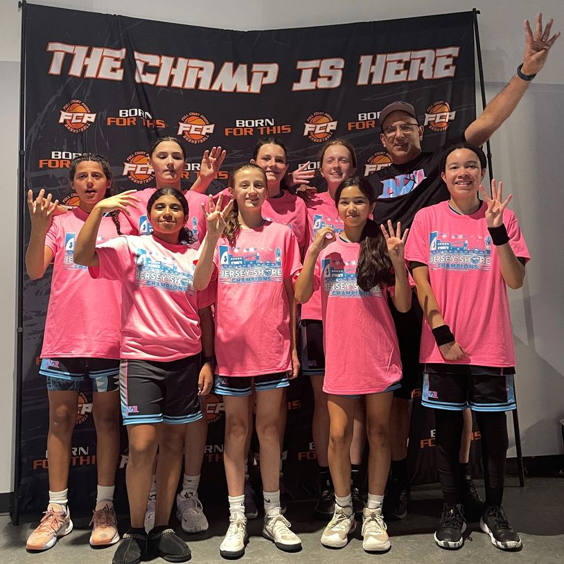 Youth basketball team celebrating their championship victory with hand signs and smiles.