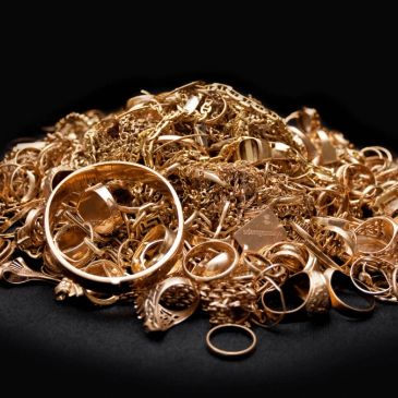 Pile of gold jewelry including rings and chains.