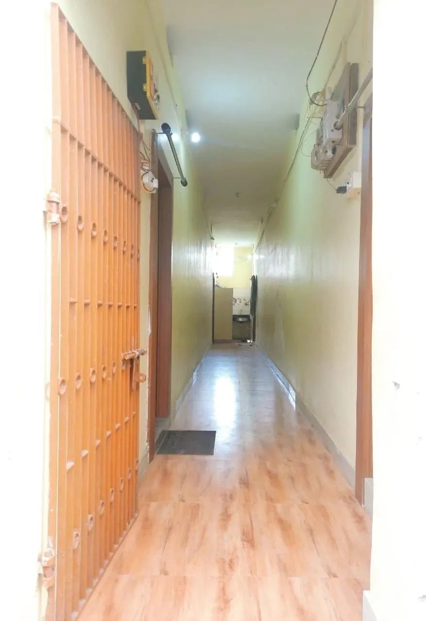 Long narrow corridor with wooden flooring and closed doors on both sides.