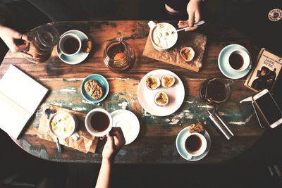 several coffee cups and pastries on a wooden table