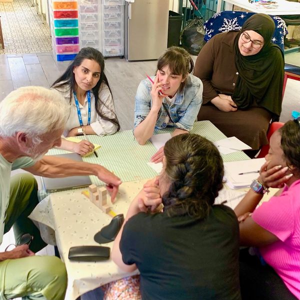 A diverse group engaged in a hands-on learning activity around a table.