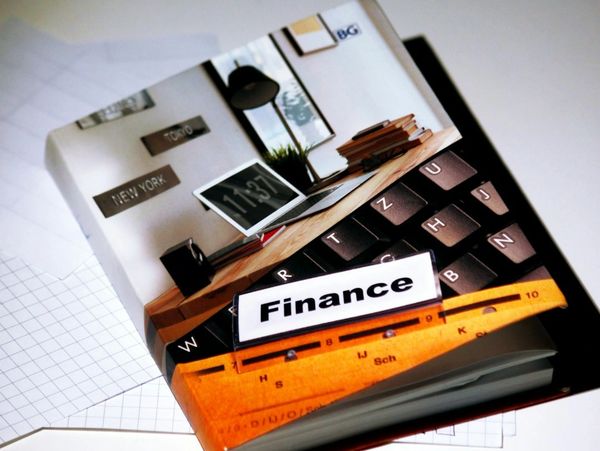 A finance book with a cover showing a workspace and keyboard on a white background.