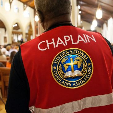 Chaplain in red vest inside a church.