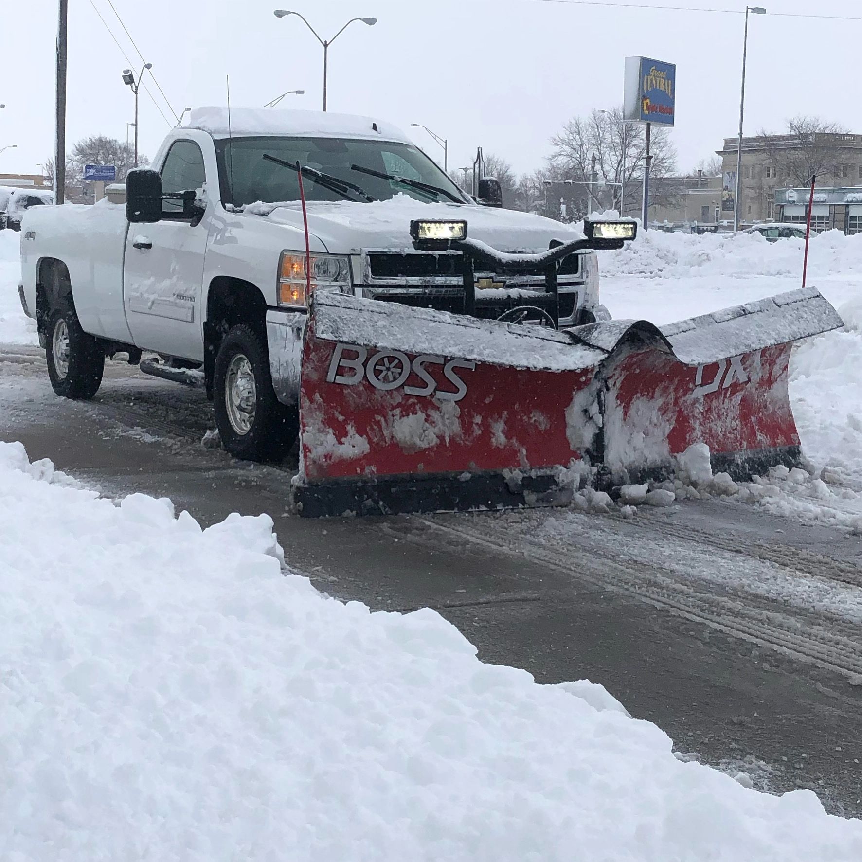Plow truck plowing snow on commercial site by Alpha Outdoor Services LLC in Kearney Ne