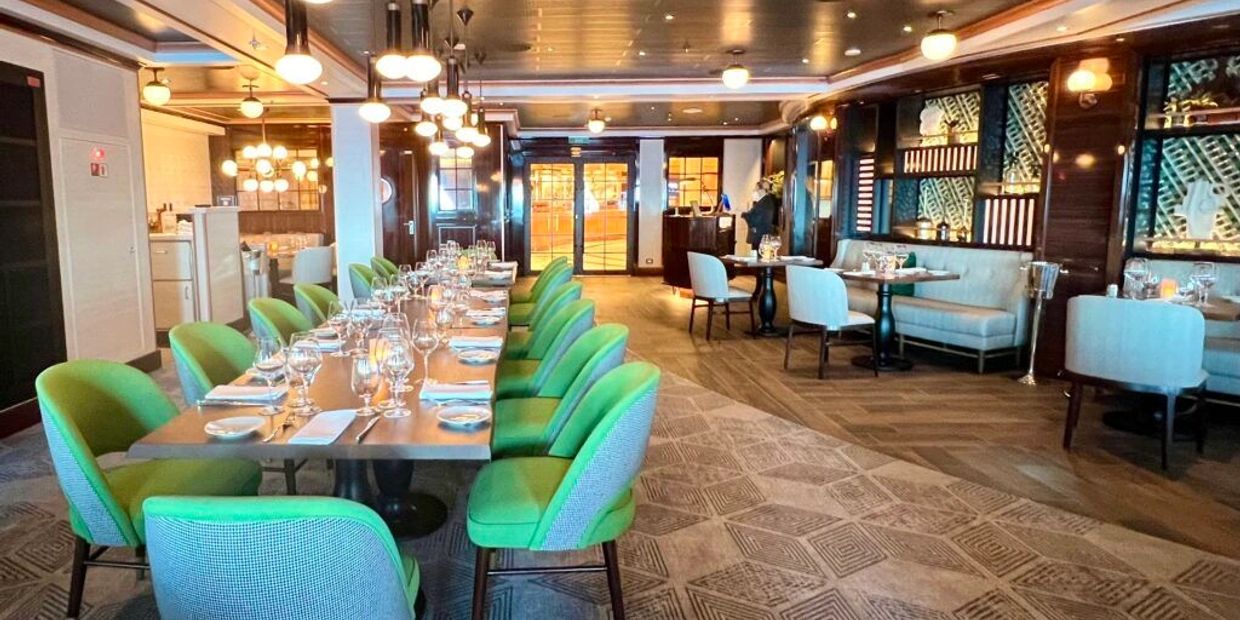 Elegant dining area with green chairs and neatly set tables.