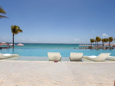 Heated infinity pool overlooking a white sandy beach and the turquise blue waters of the Bahamas