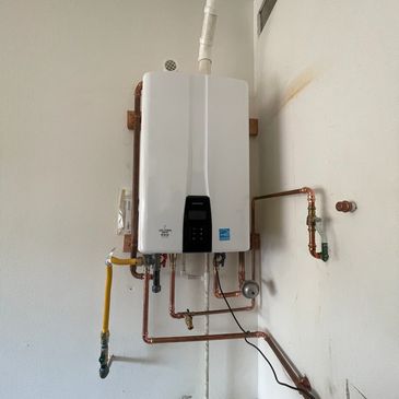 Wall-mounted tankless water heater with copper piping.
