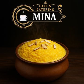 A bowl of steaming yellow dessert topped with almond slices from Cafe & Catering Mina.