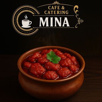 A bowl of spicy red curry garnished with coriander from Cafe & Catering Mina.