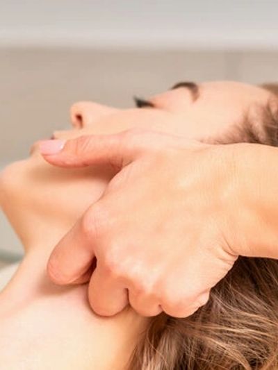 Close-up of a person receiving a neck massage.