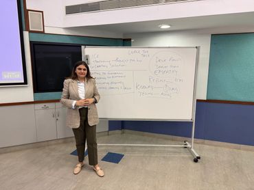 Professional woman standing in front of a whiteboard with leadership and empathy concepts written on it.