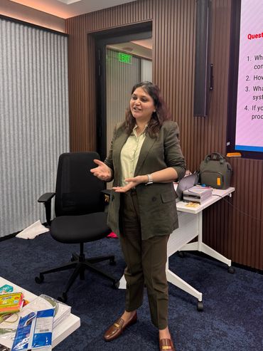 A woman in a suit giving a presentation in a modern office room.