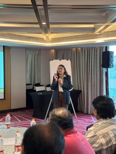 A woman giving a presentation to an audience in a conference room.