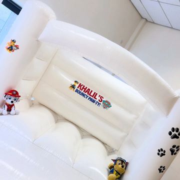 White Paw Patrol-themed bouncy castle with cartoon characters.