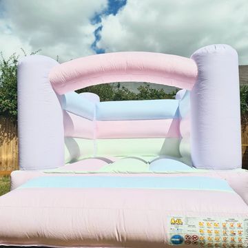 Pastel-colored bouncy castle outdoors under cloudy sky.