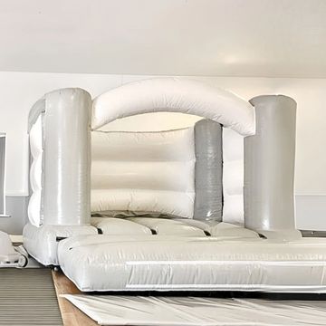 White inflatable bounce house indoors.