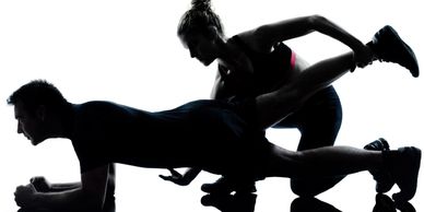 WorkoutStyles Woman Personal Trainer assisting male client with his workout