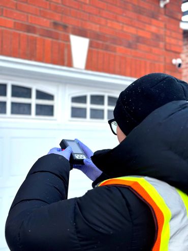 Performing a radiation measurement in the front yard to assess potential environmental radiation sou