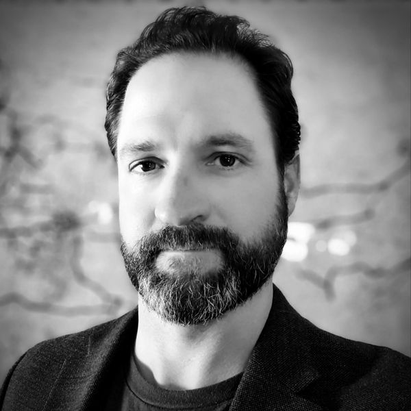 Black and white portrait of a bearded man with a calm expression.