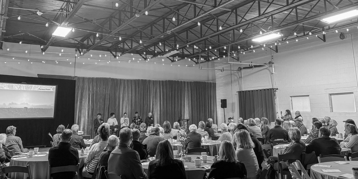 Audience attentively listening to a panel discussion in a spacious venue.