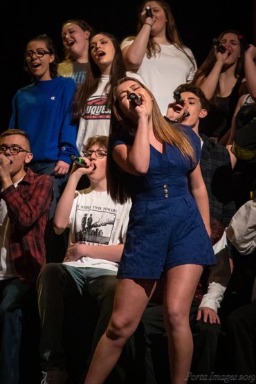 Sing-Out cast members sing a song on stage.