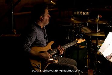 A Sing-Out band member plays the guitar.