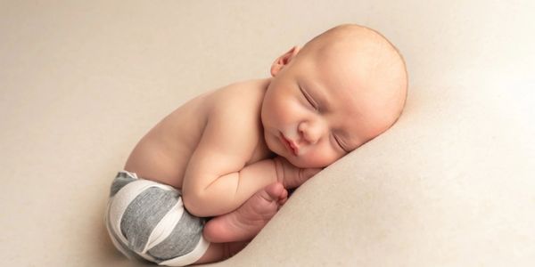 Newborn baby peacefully sleeping on a soft surface.