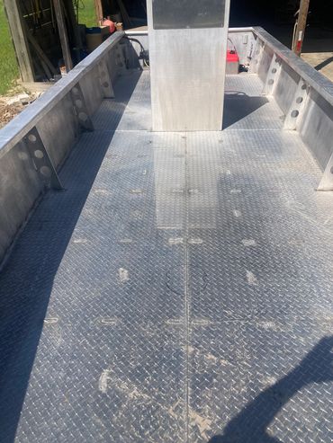 Empty aluminum boat interior with diamond plate flooring.