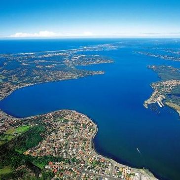 Aerial view of a large bay with surrounding residential areas and clear blue water.