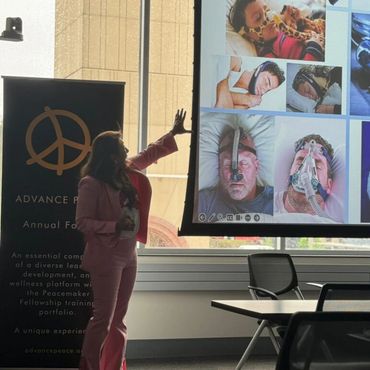 Woman gesturing toward display screen.