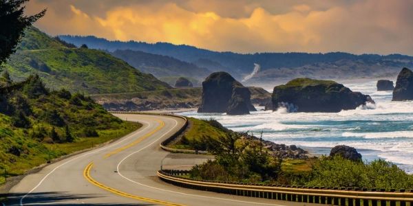 Coastal road with ocean views and rocky formations.