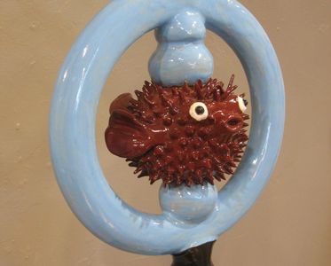 Blue ring with a maroon puffer fish swimming through